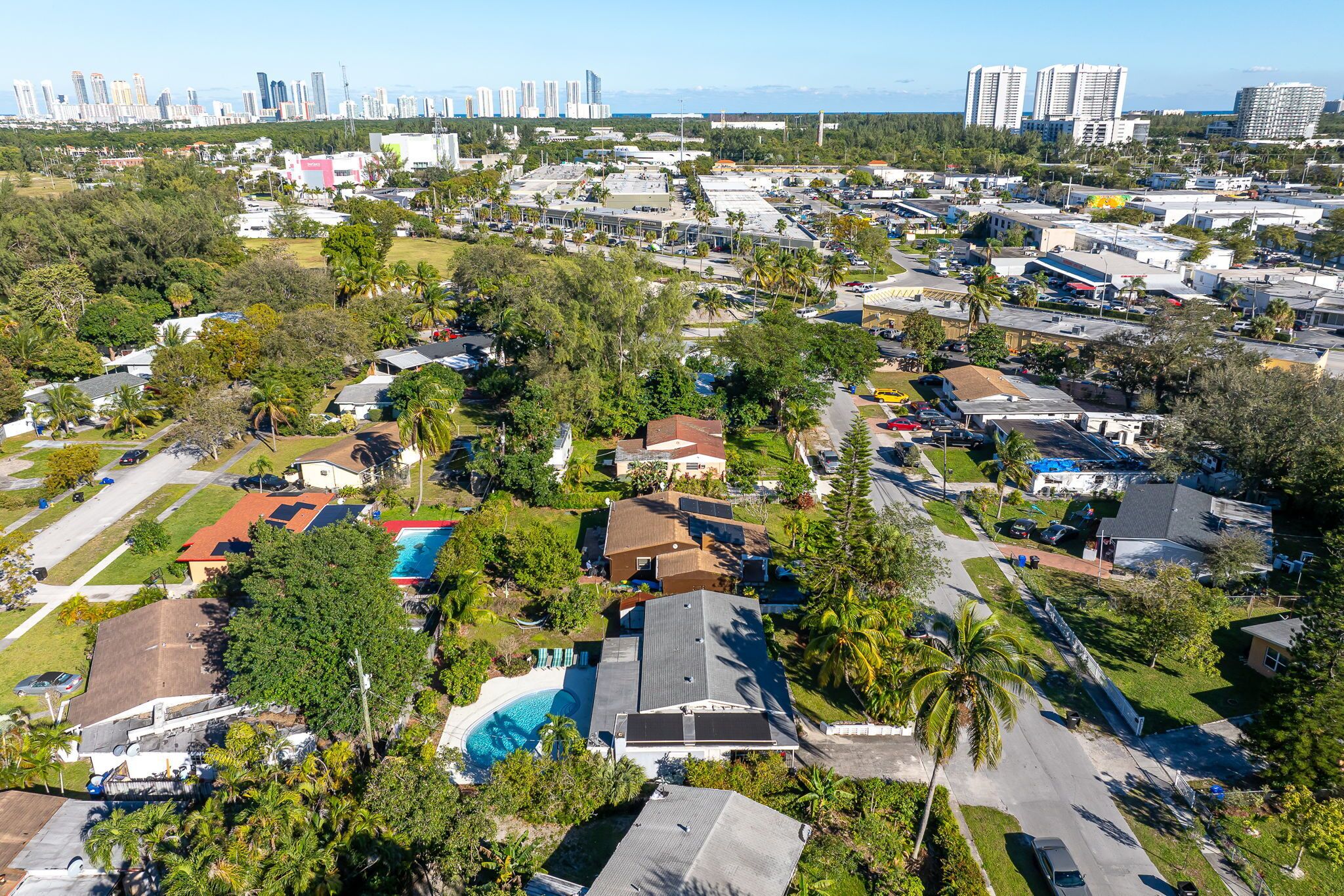 An aerial view of a residential area with houses, streets, and a large body of water.