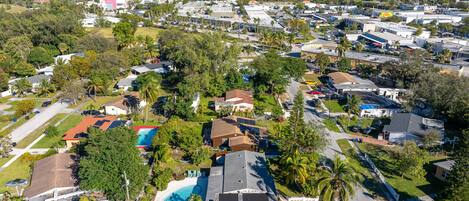 An aerial view of a residential area with houses, streets, and a large body of water.