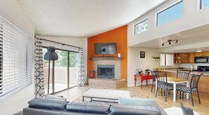Ein modernes Wohnzimmer mit Kamin, Essbereich und Küche.