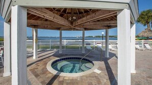 Un espace extérieur abrité avec un jacuzzi et une vue sur l’océan.