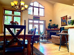 Relax in this spacious living room with a comfortable sofa, dining table, and fireplace.