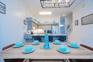 Un comedor con una mesa de madera, platos azules y un centro de mesa decorativo.