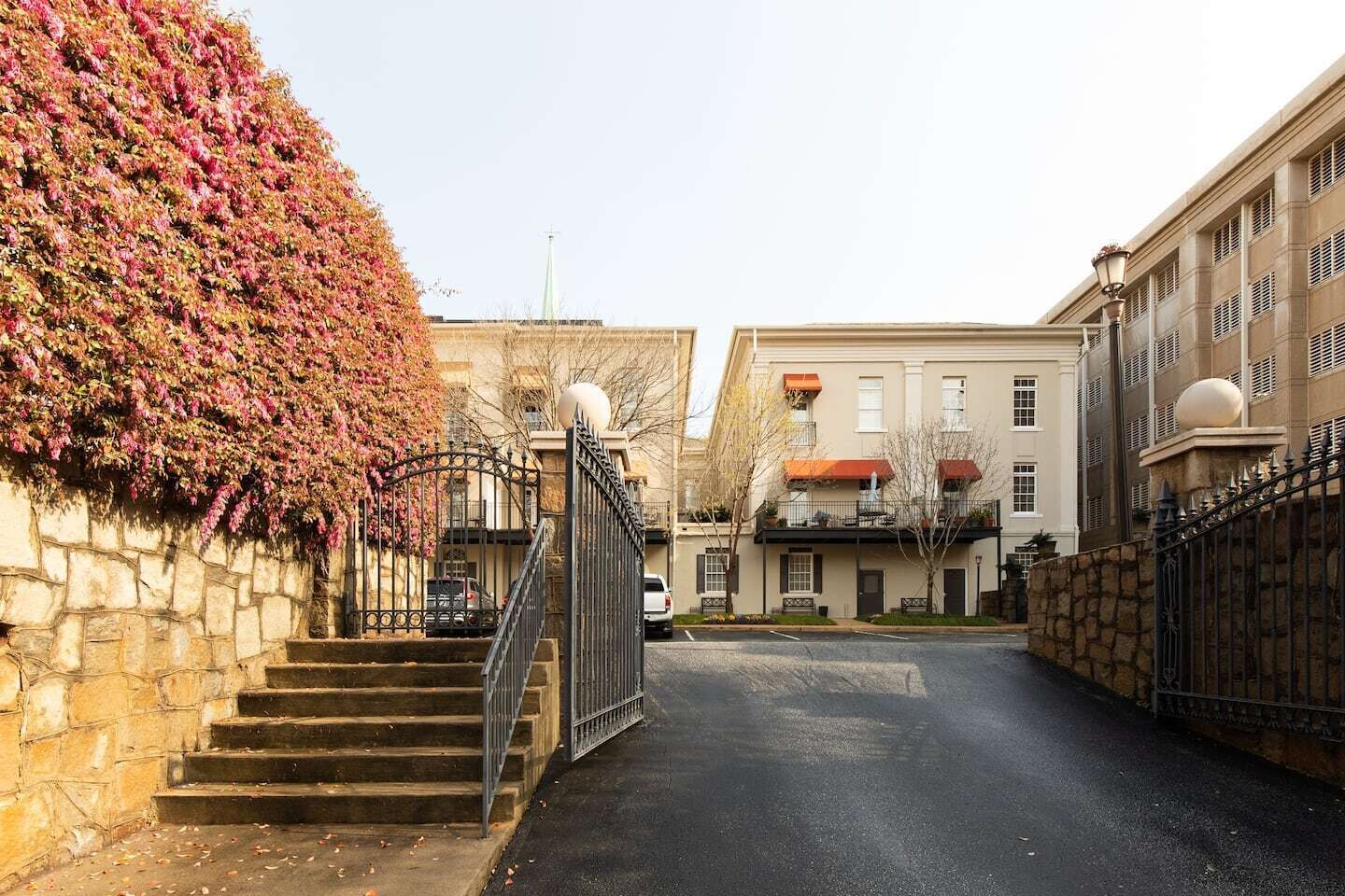 A residential building with a stone staircase leading to a gated entrance.