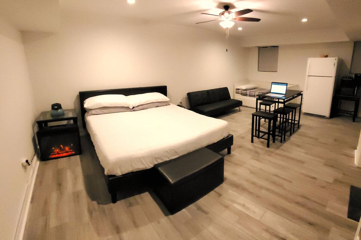 A modern bedroom with a bed, a desk, and a chair.