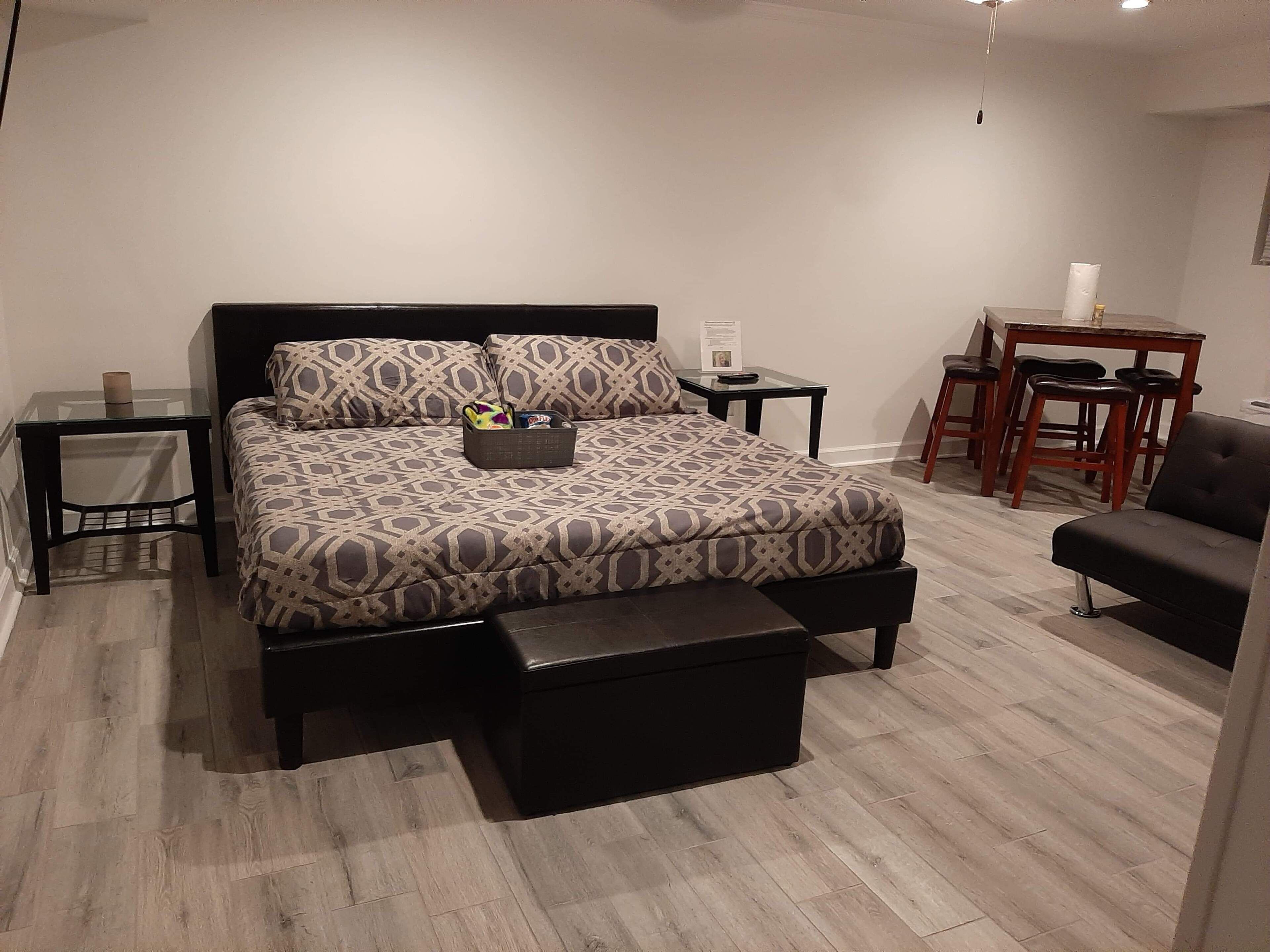 A modern bedroom with a bed, bedside tables, a desk, and a chair.