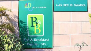 A sign for a bed and breakfast with the logo of Delhi Tourism and the name 'R&B'. - Mehra Residency at the Airport (New Delhi)