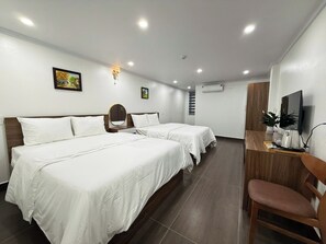 A hotel room with two beds, a desk with a TV, and a chair. - Galaxy Airport Hotel (Hanoi)