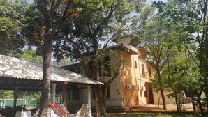 A building with a covered porch and a staircase leading to a door. - N.L.I. Guest House (Habarana)