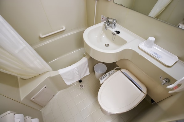 Bathroom features a bathtub, sink, toilet, and bidet, with a mirror and towel rack.