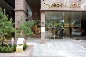 Secure entrance with a landscaped area and potted plants.