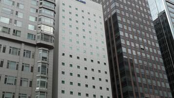 A high-rise hotel with multiple floors, a prominent sign, and surrounding modern buildings.