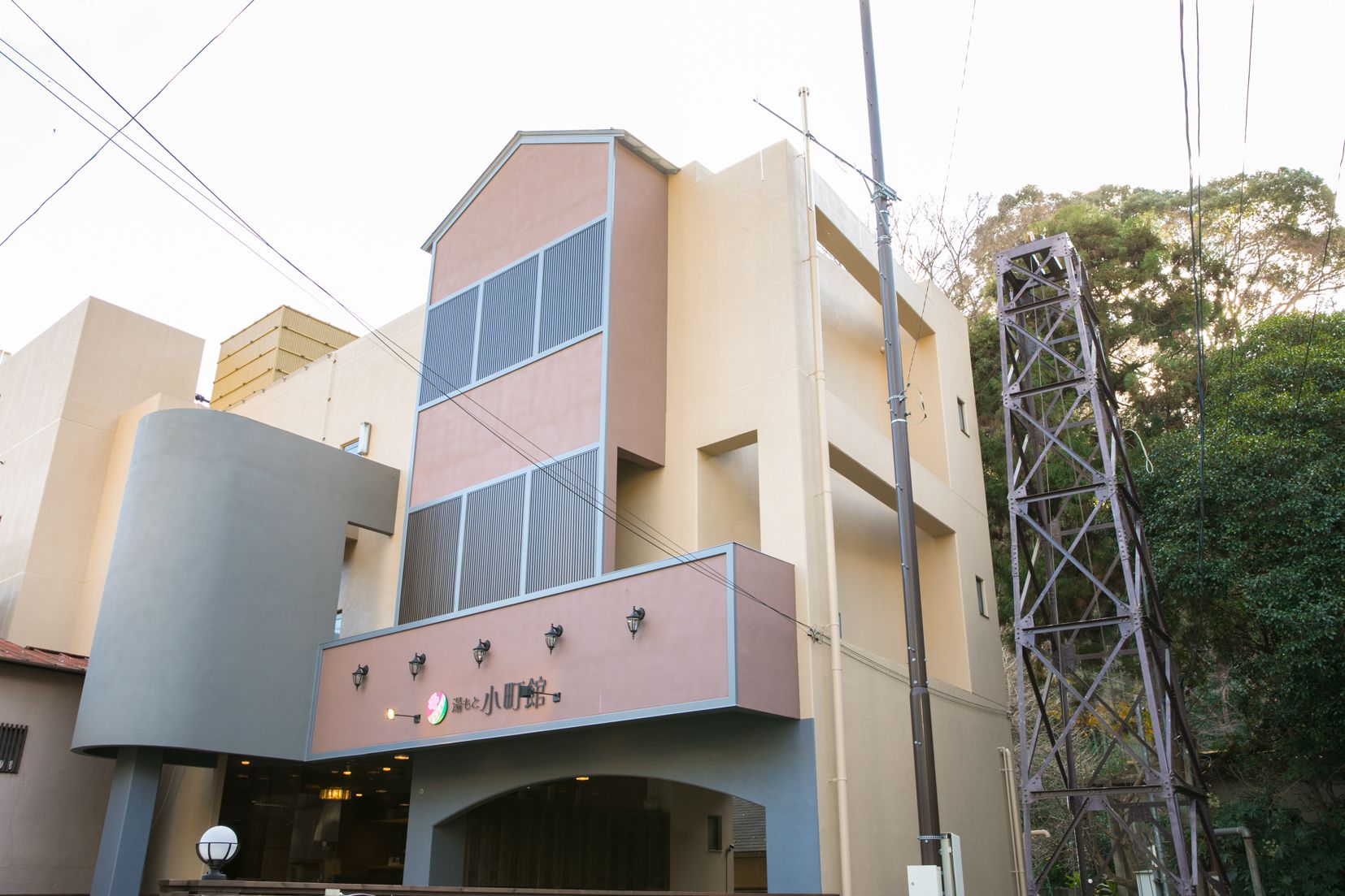 A building with a modern architectural design, featuring a flat roof and a prominent entrance with a sign.