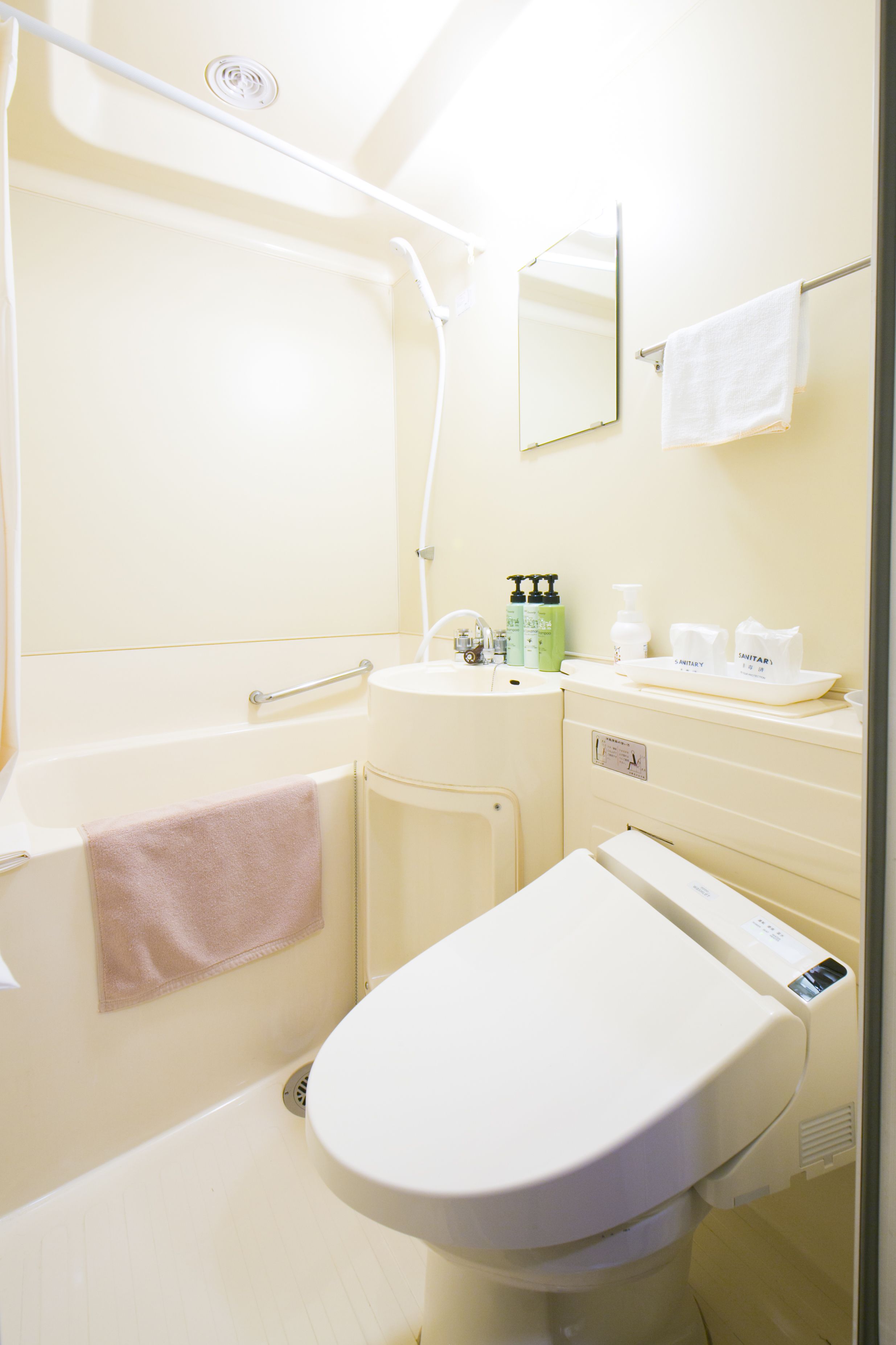 A bathroom with a bathtub, toilet, sink, and a mirror.