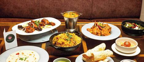 Una variedad de platos en una mesa, incluyendo arroz, curry y pan.