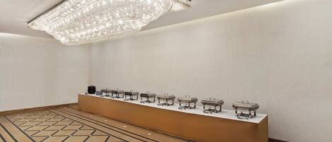 A room with a long counter, a patterned floor, and a hanging light fixture.