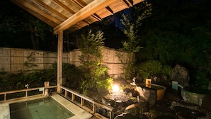A traditional Japanese onsen with a wooden deck, a stone hot spring, and a small waterfall. - Nikko Toshogu Koyoen (Nikko)