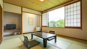 A traditional Japanese room with tatami flooring, a low table, chairs, a television, and a large window with shoji screens. - Nikko Toshogu Koyoen (Nikko)