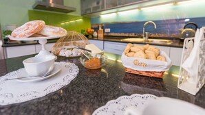 A kitchen with a marble countertop, a bread basket, a bowl of orange slices, and a decorative shell display. - Beautiful private villa for 6 guests with WIFI, A/C, TV and patio (Manacor)