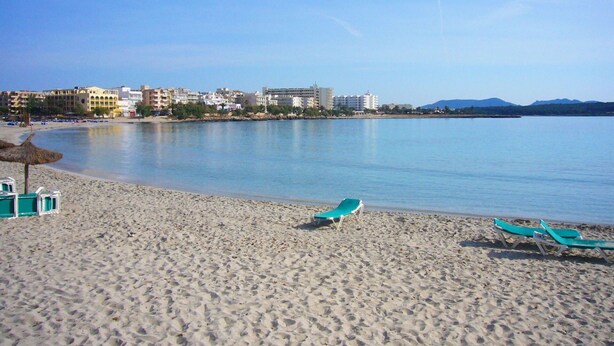 A beach with two green lounge chairs and a thatched umbrella. - Beautiful private villa for 6 guests with WIFI, A/C, TV and patio (Manacor)
