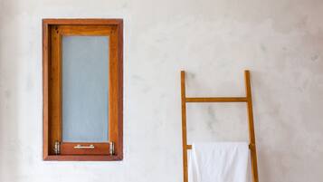 Una habitación con una ventana de madera y una escalera de madera apoyada en la pared.