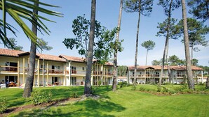 A hotel with multiple-story buildings, outdoor seating areas, and a well-maintained lawn. - Lovely apartment for 4 people with pool, WIFI, TV and terrace (Ondres)