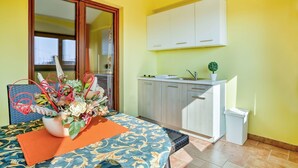 A compact kitchen with white cabinets, a sink, and a small potted plant. - Lovely apartment for 2 guests with pool, WIFI, A/C, TV and pets allowed (Umag)