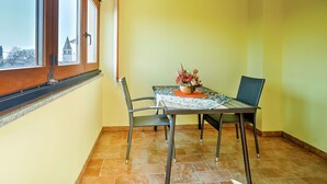 A dining area with a table, chairs, and a potted plant. - Lovely apartment for 2 guests with pool, WIFI, A/C, TV and pets allowed (Umag)