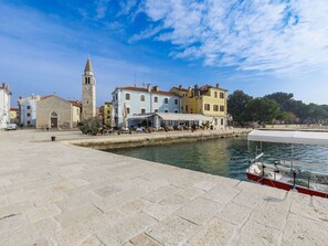A waterfront area with buildings, a clock tower, and a boat dock.