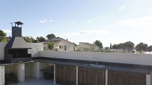 An outdoor kitchen with a grill, sink, and wooden cabinets. - Beautiful private villa for 8 guests with WIFI, private pool, TV, patio and pets allowed (L'ampolla)