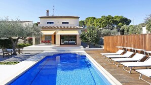 A swimming pool with lounge chairs, a patio area, and a building with a tiled roof. - Beautiful private villa for 8 guests with WIFI, private pool, TV, patio and pets allowed (L'ampolla)