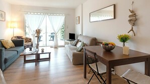 A cozy living room with a sofa, a dining table, and a TV. - Stunning  villa for 4 people with WIFI, TV, terrace and pets allowed (Mimizan)