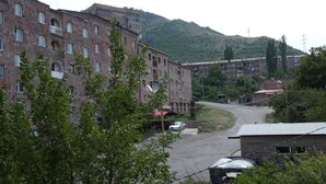 A multi-story building with a parking area in front. - Sanahin Bridge Hotel (Alaverdi)