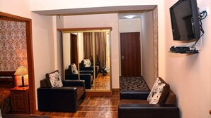 A living room with a sofa set, a television mounted on the wall, and a wooden floor. - Sanahin Bridge Hotel (Alaverdi)