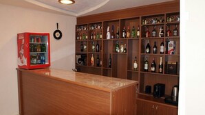 A bar area with a wooden counter and shelves stocked with various liquor bottles. - Sanahin Bridge Hotel (Alaverdi)