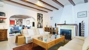 Ein Wohnzimmer mit Kamin, einer Couch, einem Couchtisch und einem Bücherregal.