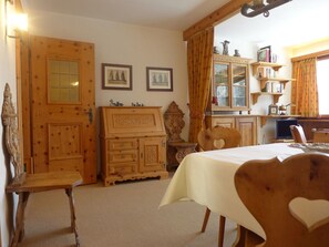 A cozy room with a wooden dresser, a bed with a heart-shaped headboard, and a desk with a laptop.