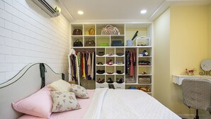 Une chambre à coucher comprenant un lit, une armoire et un bureau avec une chaise.