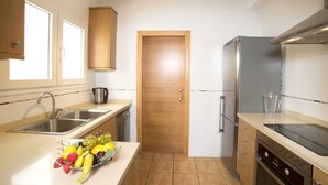 A modern kitchen with a stainless steel sink, a coffee maker, a fruit bowl, a refrigerator, and a stove. - Beautiful  villa for 6 people with WIFI, private pool, TV, terrace and panoramic view (Calpe)