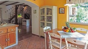 A dining area with a table set for four, surrounded by white chairs with heart cutouts. A fruit bowl is on the table. - Wonderful private villa with WIFI, private pool, hot tub, A/C, TV, patio and pets allowed (Rijeka)