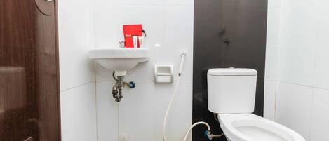 A bathroom with a toilet, sink, and a red box on the wall.