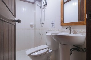 A bathroom with a toilet, a sink, and a shower. - RedDoorz @ Moonwalk Paranaque (Parañaque)