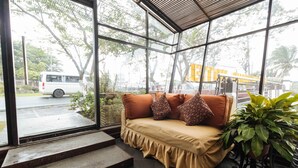 Una habitación moderna con sofá, un ventanal grande y una escalera que da al exterior.