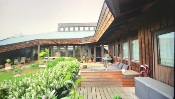 A modern house with a covered patio, outdoor seating, and a garden. - Steinacher Hof (Fuerth)