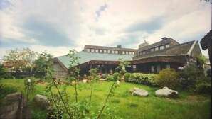 A large, rustic building with a sloped roof and a prominent chimney. - Steinacher Hof (Fuerth)