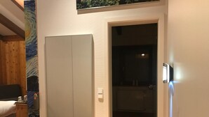 A hotel room with a bed, a wardrobe, and a bathroom visible through an open door. - Steinacher Hof (Fuerth)