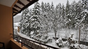 A balcony with a view of snow-covered trees and a road. - Hotel Conca D'Oro (Lama Mocogno)