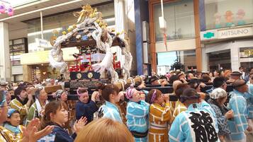 A crowded indoor event with a central display featuring a decorated structure.