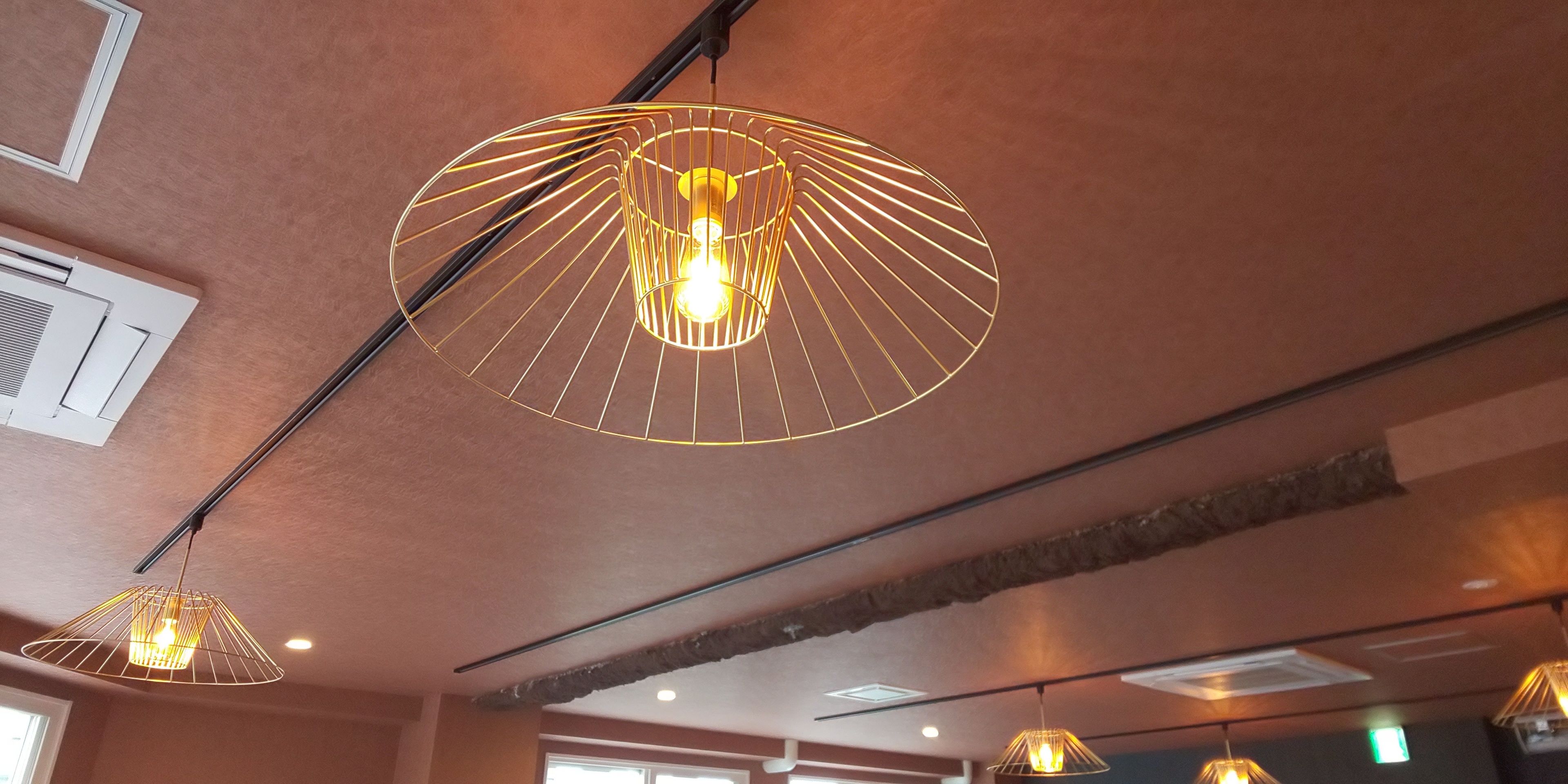 A modern interior with pendant lighting fixtures and exposed brick walls.