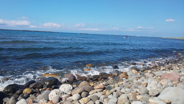 A rocky shoreline with waves crashing onto the pebbles. - Otaru YaDo - Hostel (Otaru)