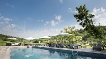 Una piscina al aire libre de temporada, sombrillas